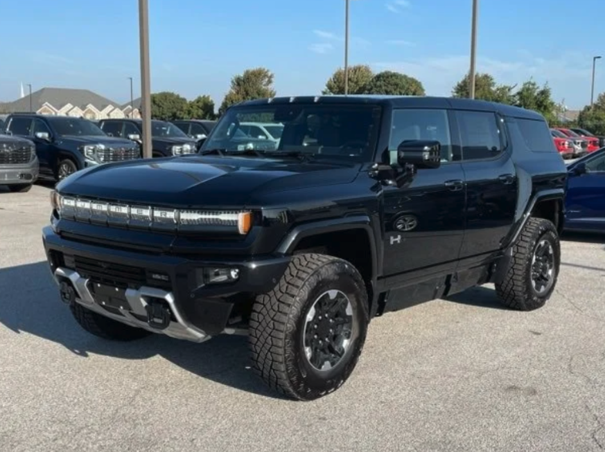 Front and side view of a black GMC Hummer EV SUV parked at Crain Buick GMC in Springdale, Arkansas